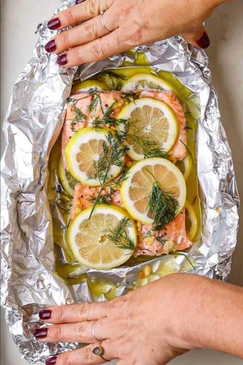 Salmon with lemon and dill in foil, baking seafood recipe, healthy salmon dinner, baked fish with lemon and herbs.