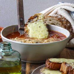 Creamy cheesy lasagna soup served with crusty bread and fresh herbs. Perfect comfort food recipe from Baked Bree.