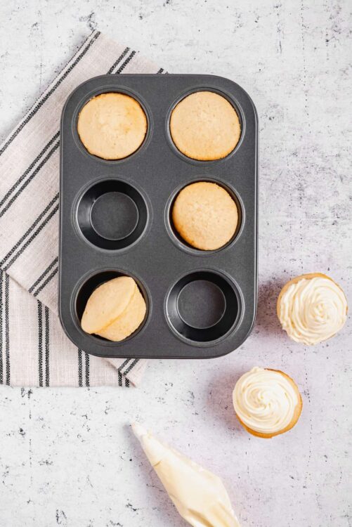 Light, golden vanilla cupcake batter in a non-stick muffin tin for baking cupcakes.