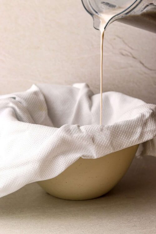 Cream pouring into a bowl through a cheesecloth for baking or cooking.