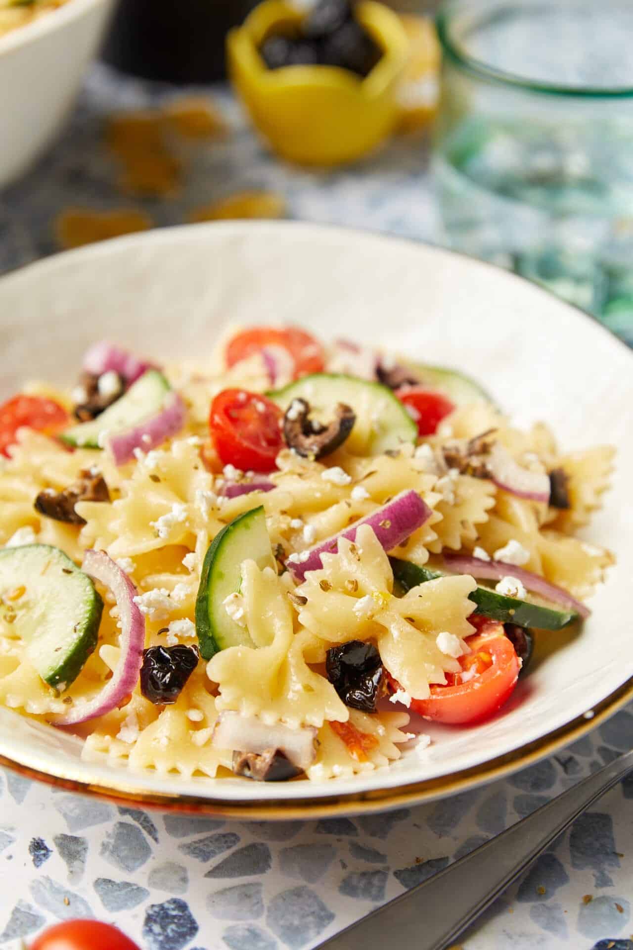 Fresh vegetable pasta salad with cherry tomatoes, cucumbers, red onions, black olives, and feta cheese.