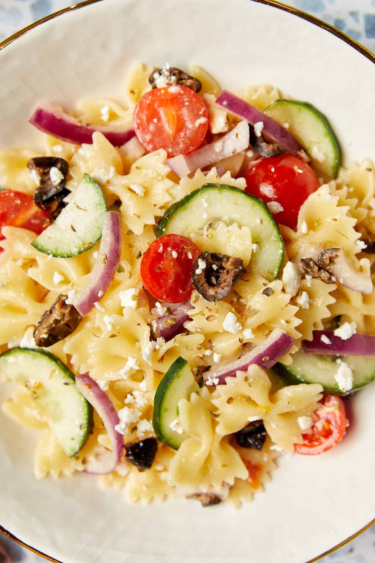 Creamy pasta salad with cherry tomatoes, cucumbers, red onion, and feta cheese. Perfect summer side dish or light lunch.