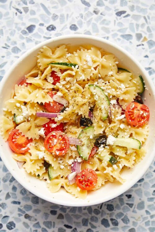 Creamy pasta salad with cherry tomatoes, cucumber, black olives, and feta cheese.