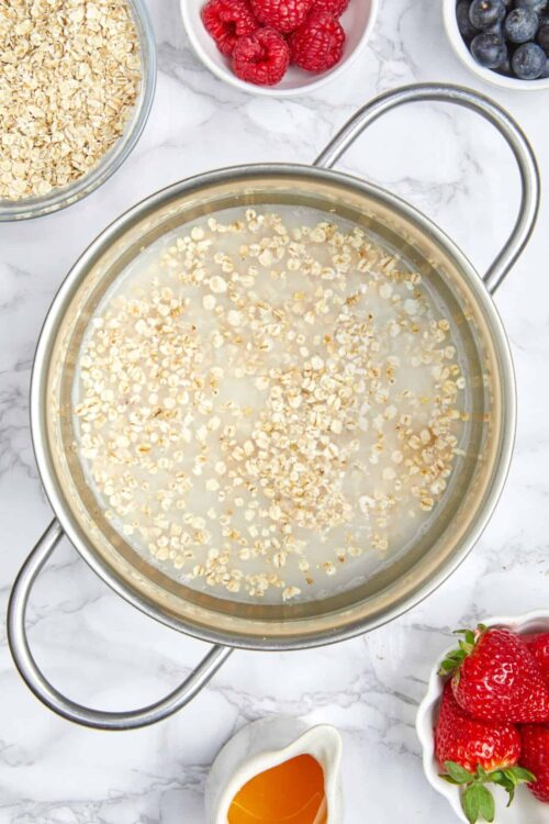 Flaked oats in water, breakfast ingredients, healthy oatmeal preparation, natural breakfast, wholesome oats.