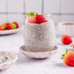 Fresh strawberry chia pudding in a glass with chia seeds and strawberries on top, healthy breakfast recipe.