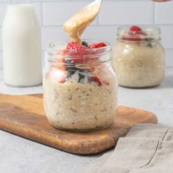 Fresh overnight oats with berries in a glass jar, topped with creamy yogurt.