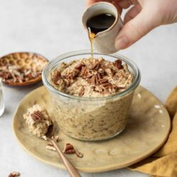 Creamy overnight oats with chopped pecans and dark coffee drizzle, served in a glass jar for breakfast.