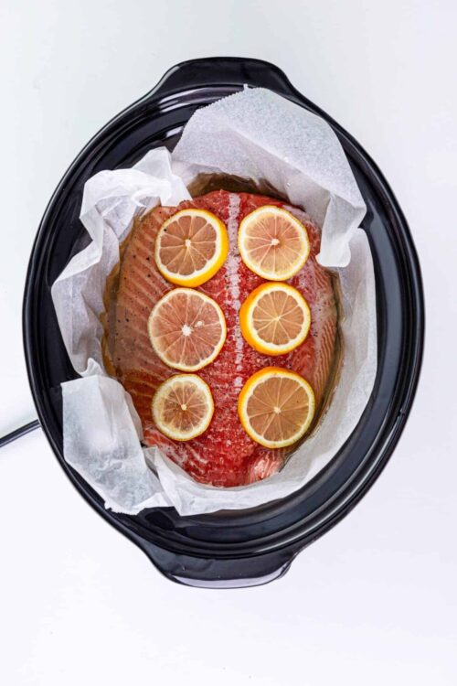 Fresh fish with lemon slices in slow cooker, healthy seafood meal prep, baked fish recipe, clean eating dinner option, easy fish cooking ideas.