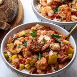 Savory shrimp and chicken rice bowls with vegetables, served with crusty bread.