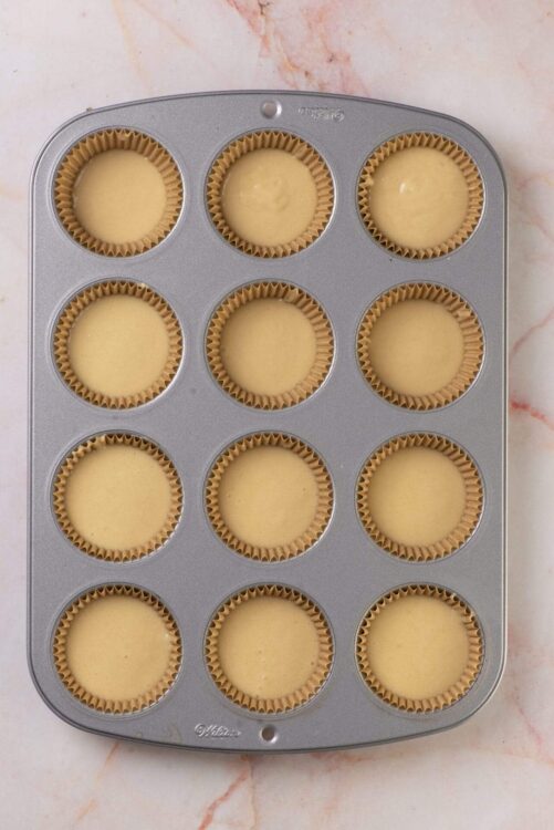 Baked cupcake batter in a muffin tin ready to bake.