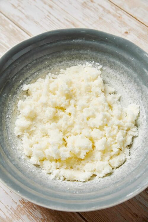 Buttery pastry dough mixture in a ceramic bowl for baking recipes.