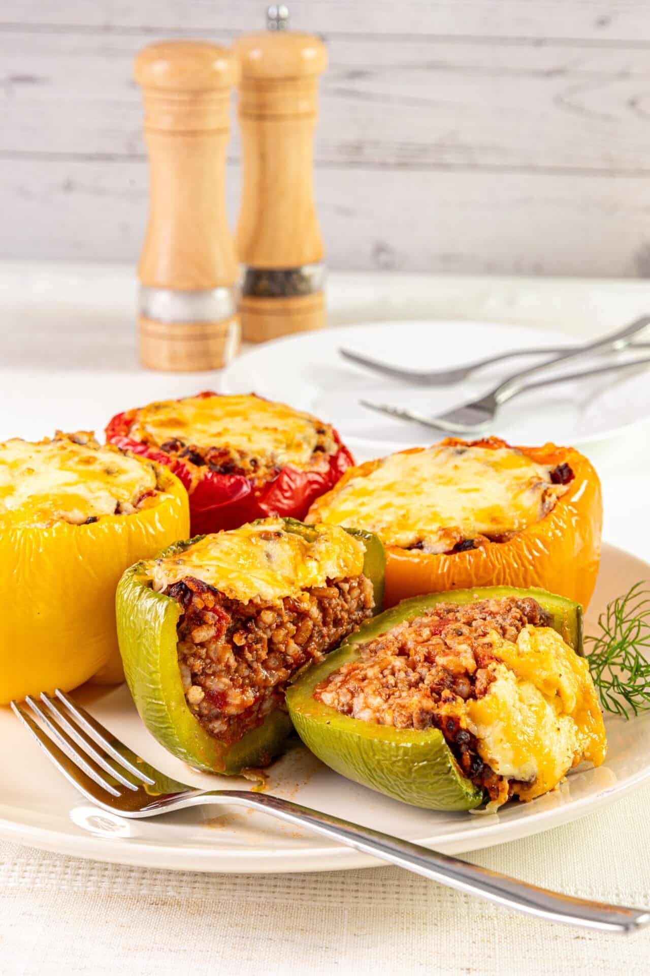 Stuffed bell peppers with ground meat, cheese, and rice, baked to perfection. Delicious and easy dinner or family meal idea.