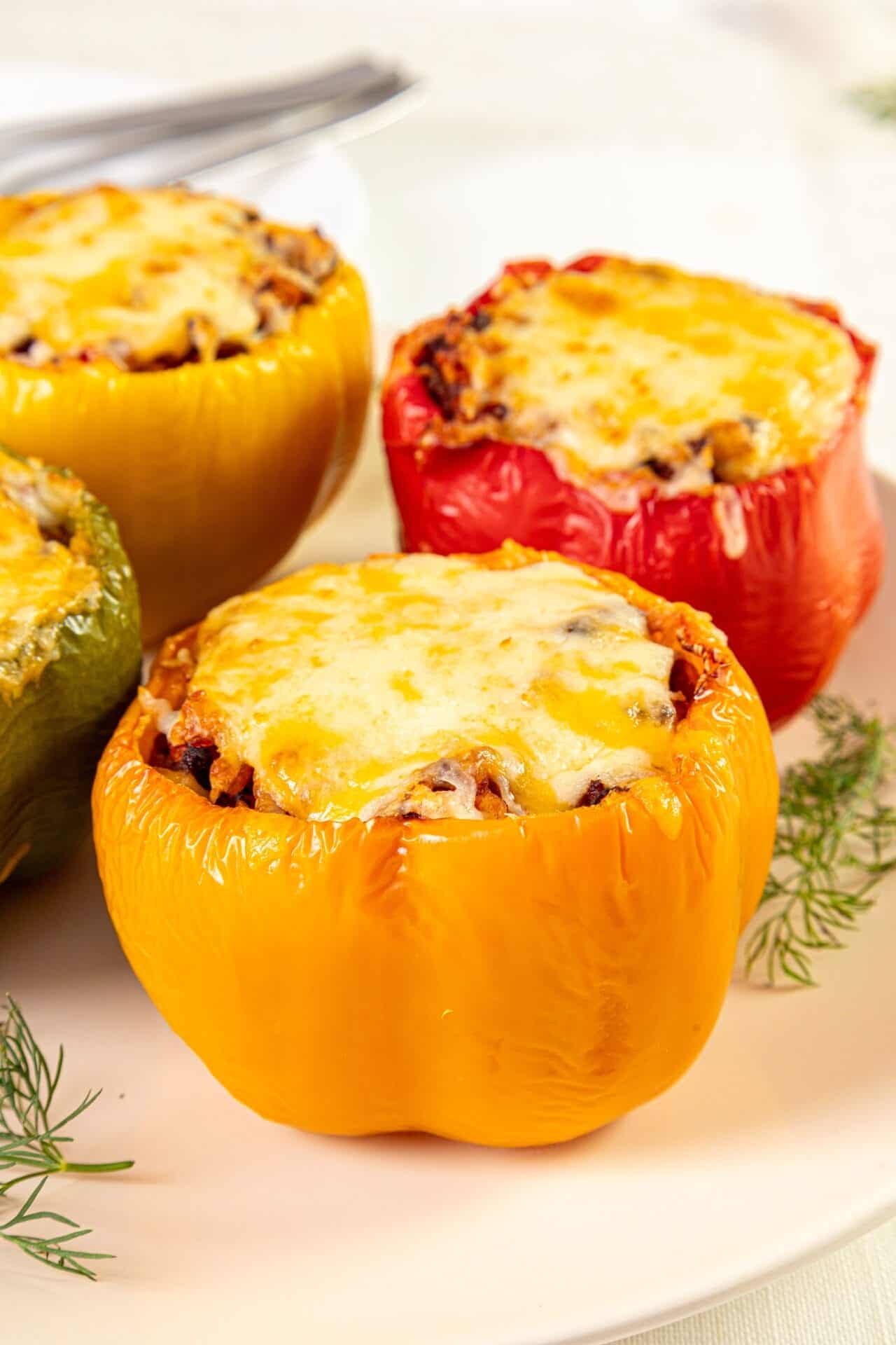Colorful stuffed bell peppers with melted cheese on top, baked to perfection.