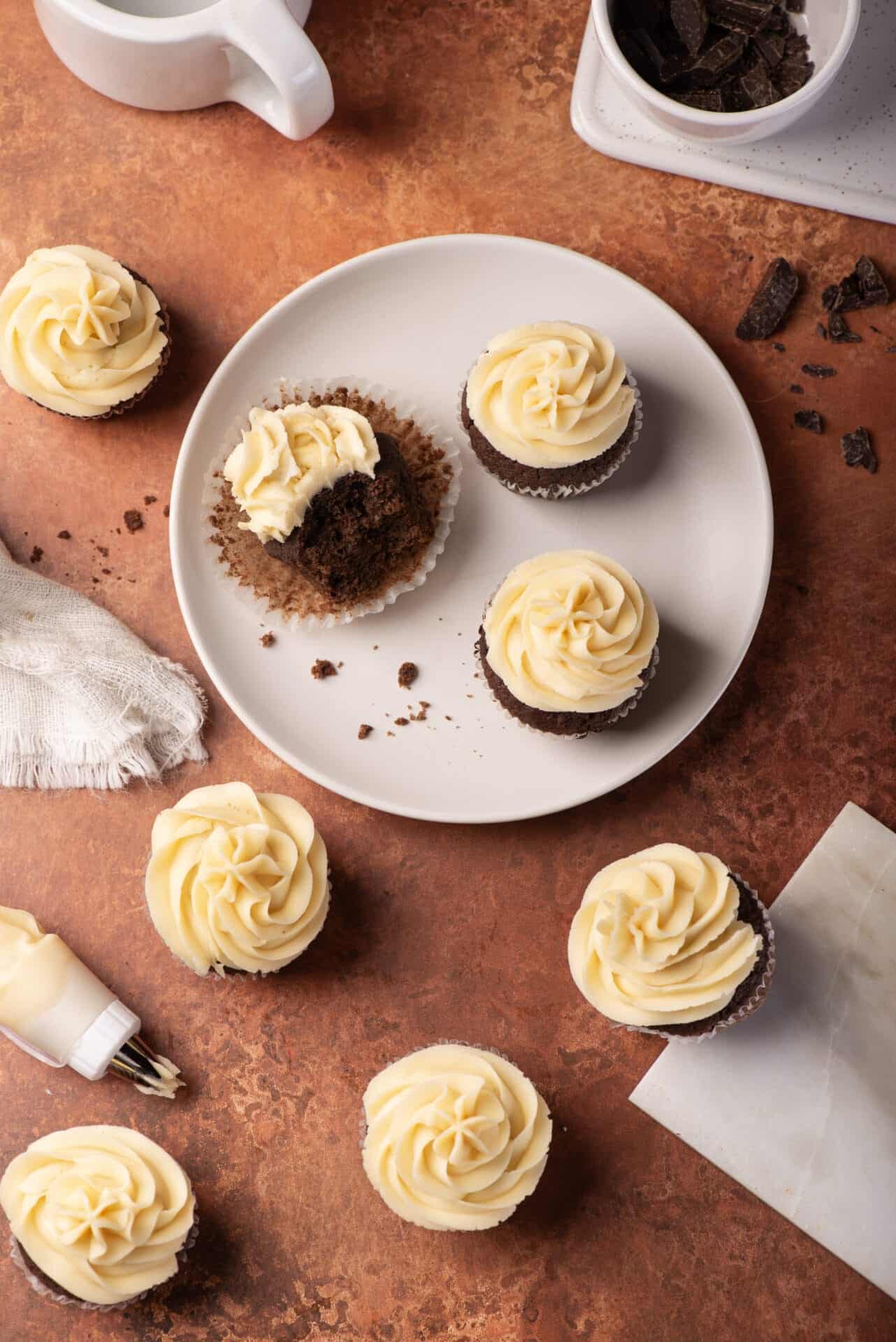 Decadent chocolate cupcakes with vanilla buttercream frosting on a white plate. Perfect for desserts or special occasions.