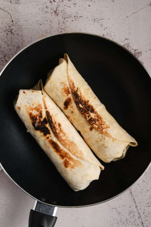Crispy beef burritos in a black skillet, homemade Mexican food, baked bree recipe.