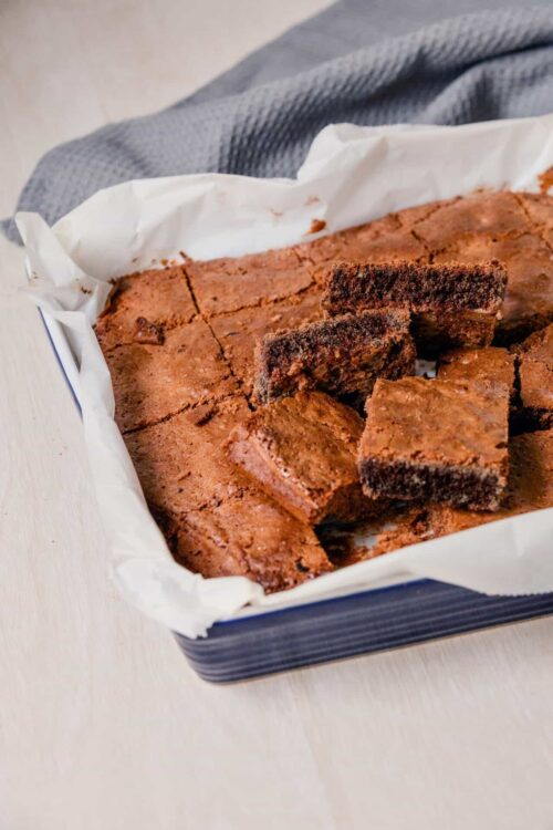 Rich, homemade chocolate brownie bars in a baking tray lined with parchment paper. Perfect for dessert or snack.