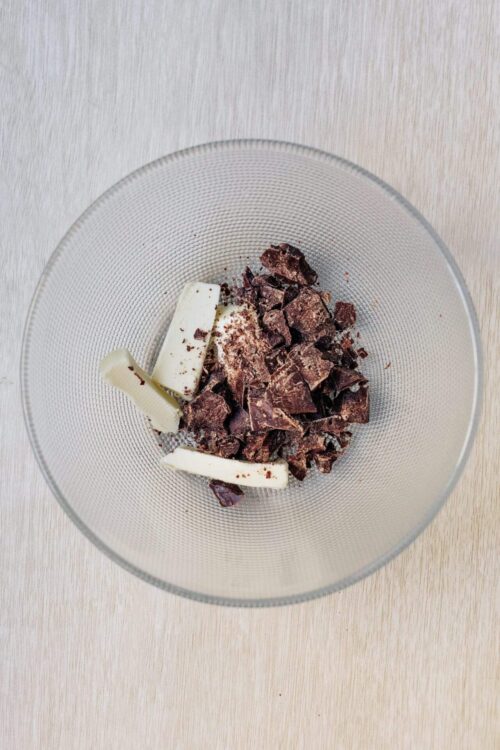 Chocolate chunks and white chocolate pieces in a glass bowl, ready for baking or chocolate recipes.