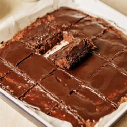 Rich chocolate brownies with glossy chocolate glaze in a baking dish. Perfect for dessert lovers and chocolate craving cravings.