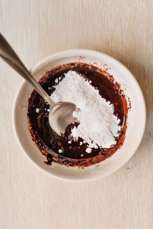 Bittersweet chocolate sauce with powdered sugar, ready for dessert or baking.