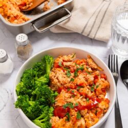 Baked cheesy chicken casserole with broccoli in a white bowl for family dinner.