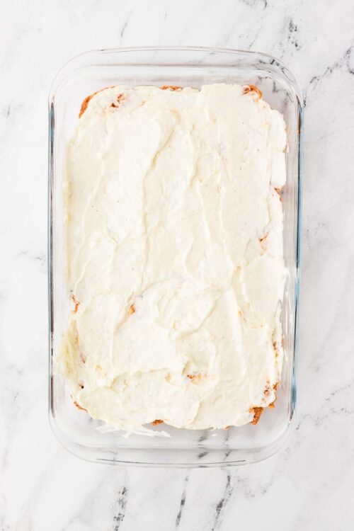 Creamy homemade lasagna with ricotta and mozzarella cheese in a glass baking dish.