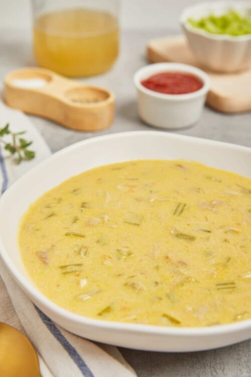 Creamy potato leek soup in a white bowl, garnished with fresh herbs. Perfect comfort food for a cozy meal.