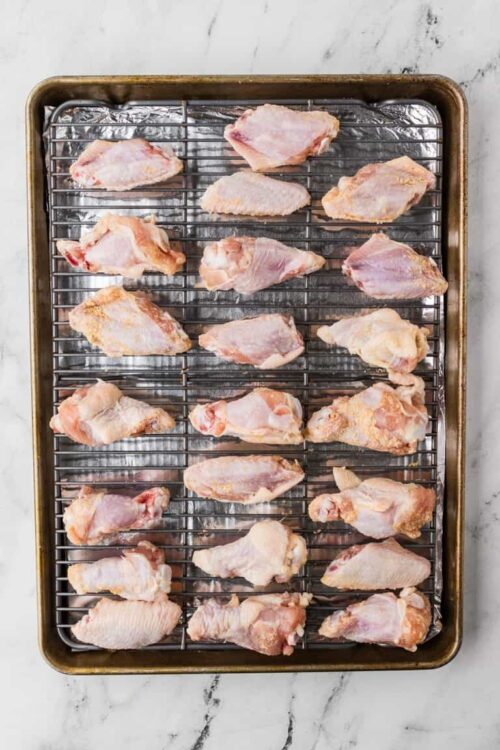 Raw chicken wings on a baking sheet for baking or roasting.