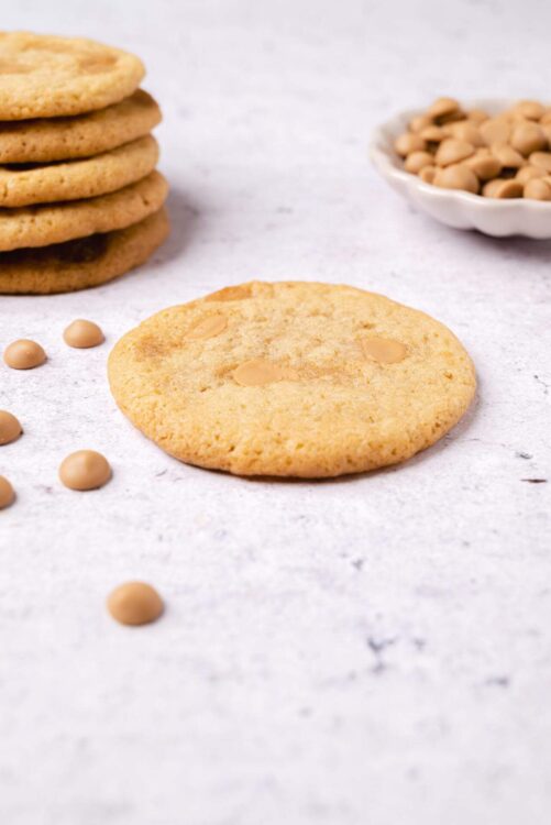 Cookies with white chocolate chips and a stack of cookies in the background.
