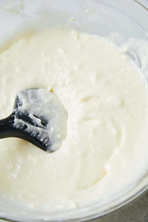 Creamy homemade cheese sauce in a glass bowl with a spatula. Perfect for pasta, nachos, or dipping. Easy cheese sauce recipe from Baked Bree.