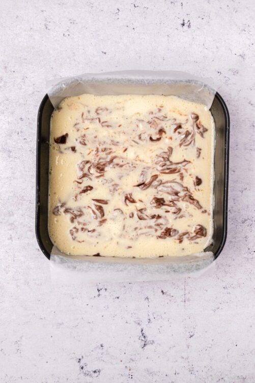 Rich chocolate and vanilla layered dessert in a baking pan, ready to bake.