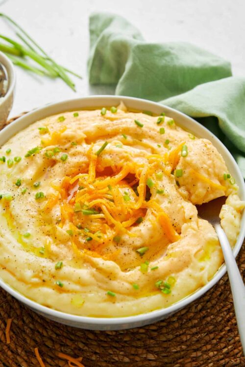 Creamy cheesy mashed potatoes with melted cheddar cheese and chopped chives.