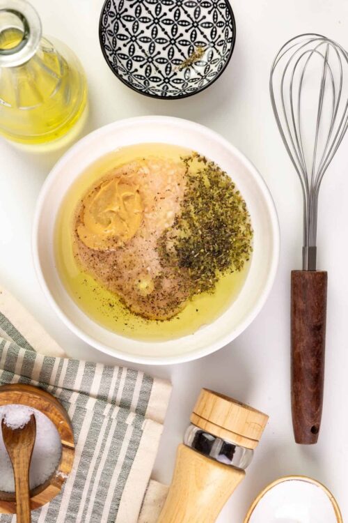 Butter mixture with spices and herbs in a white bowl for baking or cooking recipes.