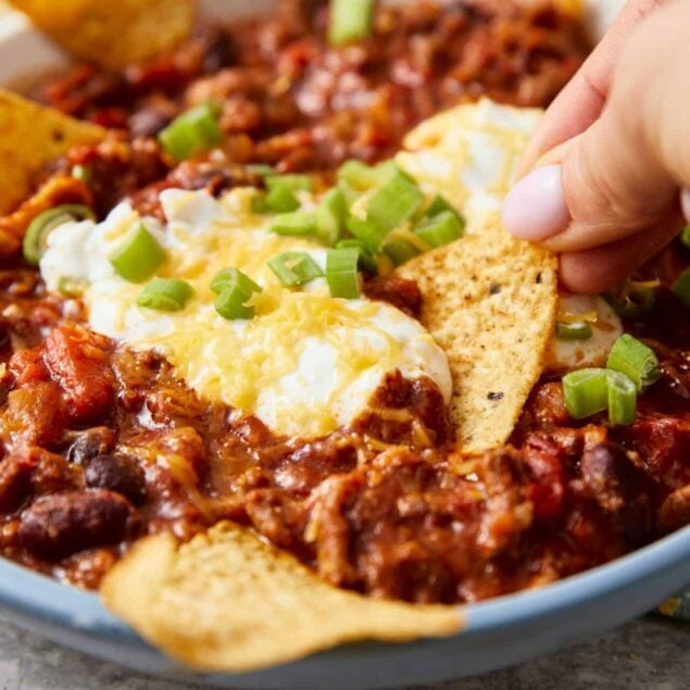 Crunchy tortilla chips and melted cheese in a hearty beef chili topped with green onions and sour cream.