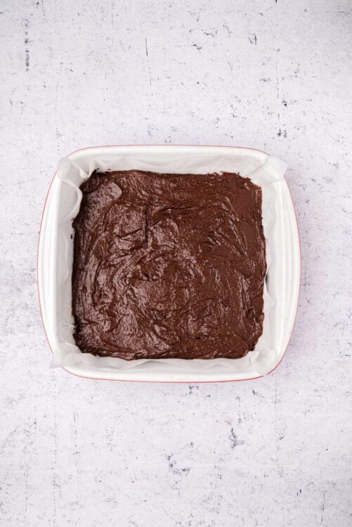 Rich chocolate brownie batter in a baking dish, ready to bake.