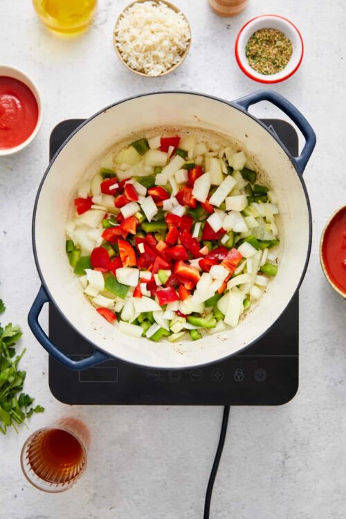 Fresh chopped vegetables in a white Dutch oven for cooking soup or stew.