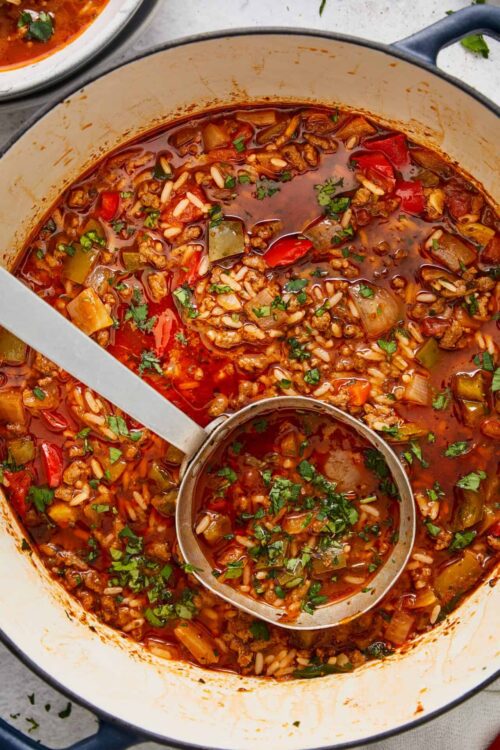 Rich beef and vegetable stew in a Dutch oven with fresh herbs.
