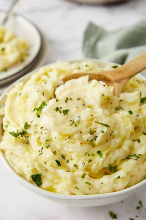 Creamy homemade mashed potatoes with parsley garnish. Perfect comfort food recipe for family dinners and holidays.