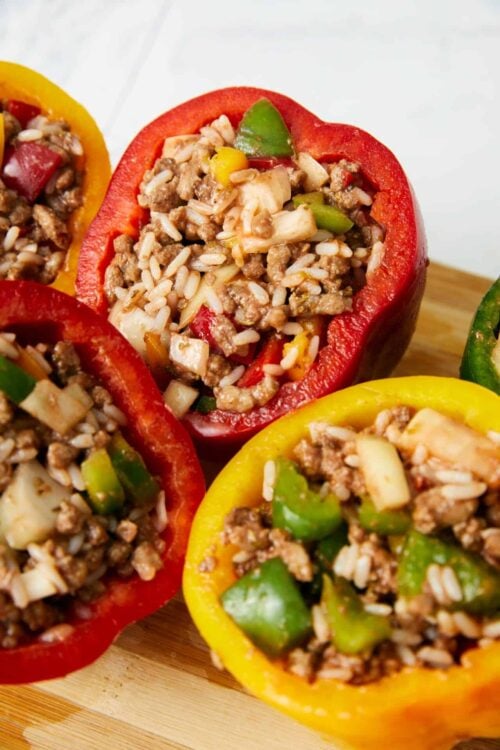 Colorful stuffed peppers filled with ground beef, rice, and savory vegetables on a wooden board, perfect for easy dinner recipes.