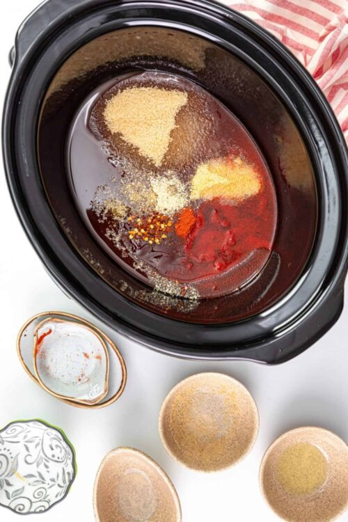 Soy sauce and seasoning ingredients in a slow cooker, preparing for Asian cuisine.