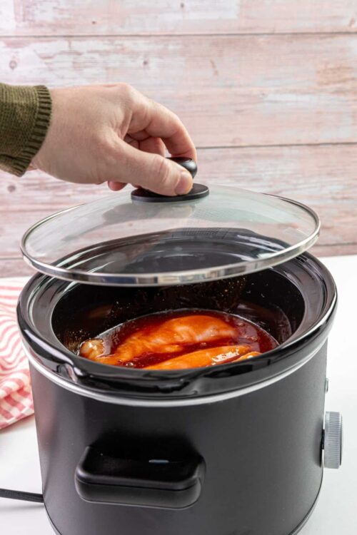 Creamy slow cooker BBQ chicken in a black pot, ready to serve.