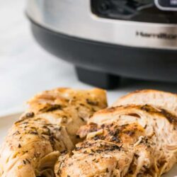 Juicy, herb-marinated cooked chicken breast on a white plate, ready to serve with instant pot description.