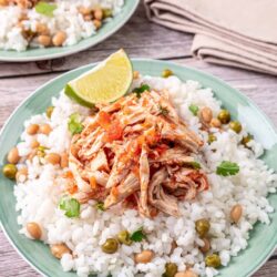 Tender shredded chicken served over fluffy white rice with beans and fresh lime wedges. Perfect for easy, flavorful chicken tacos or rice bowls.
