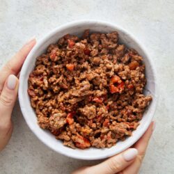 Ground beef chili served in a white bowl, cooked with diced tomatoes and spices, popular comfort food recipe.