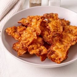 Crispy homemade bacon fried to perfection on a white plate.