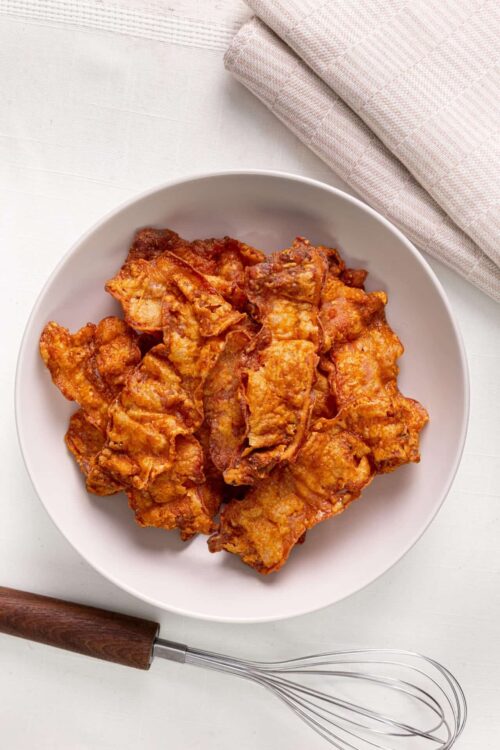 Crispy homemade fried chicken on a white plate with a fork.