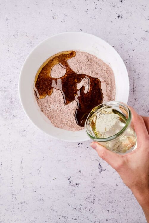 Rich chocolate and oil mixture in bowl for baking or dessert recipes.