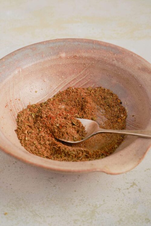 Seasonings in a rustic pink bowl for baking and cooking.