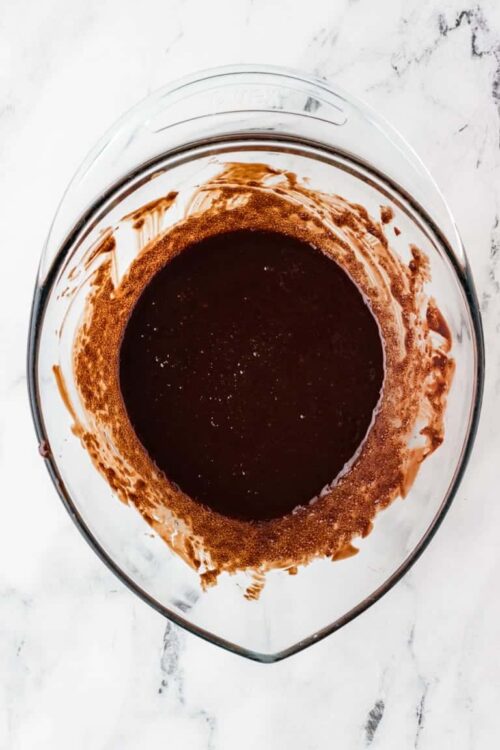 Rich chocolate sauce in a clear glass dish.