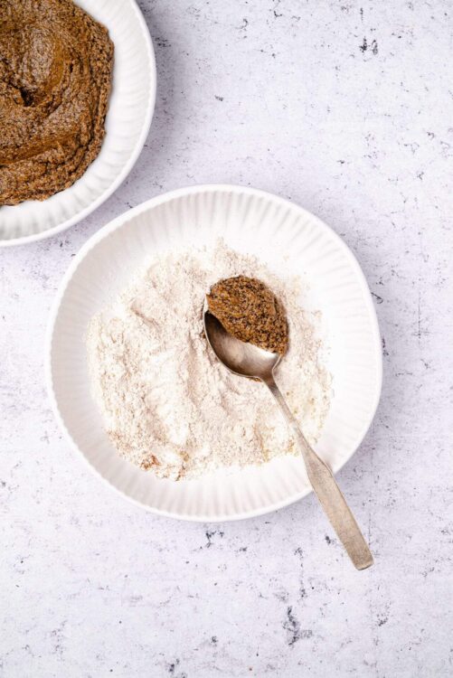 Homemade gingerbread cookie dough ready for baking on a textured white surface.