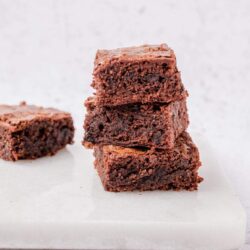 Fudgy chocolate brownies stacked on white marble, rich and gooey dessert, baked good from Baked Bree.